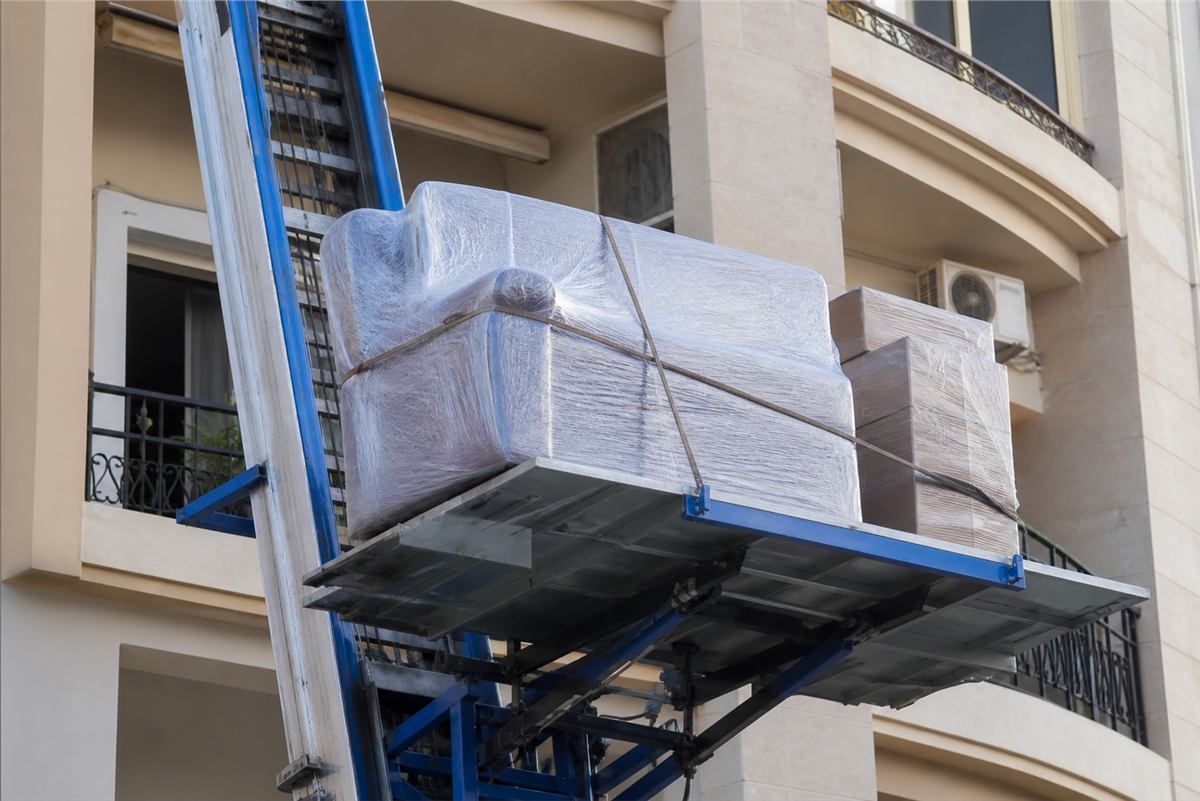 Wrapped furniture secured on hydraulic lift platform