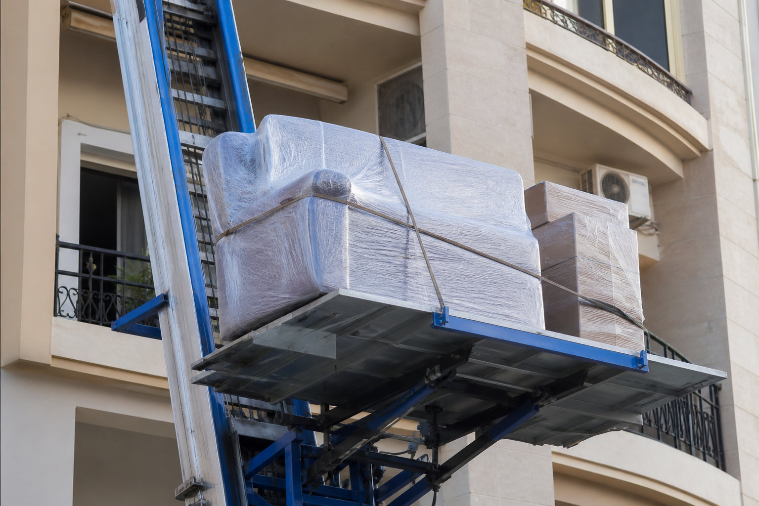 Wrapped furniture secured on hydraulic lift platform